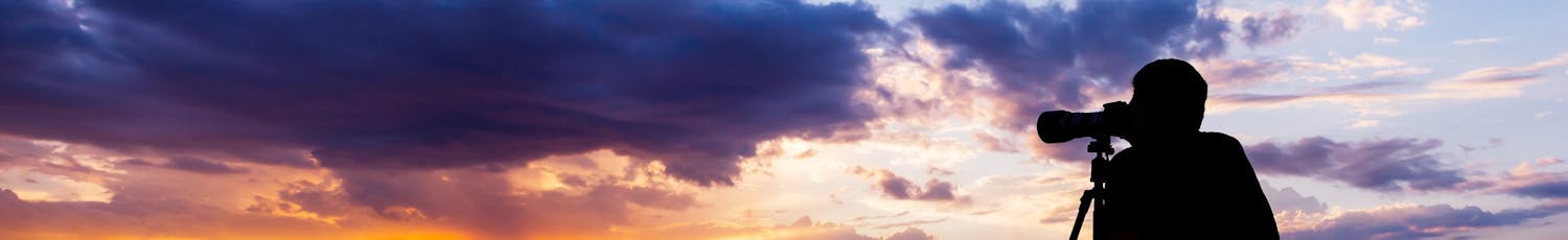 Valokuvaaja kuvaa auringonlaskua.